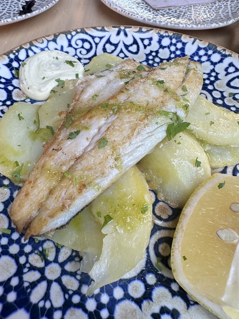 Filete de pescado fresco a la plancha con patatas y limón.