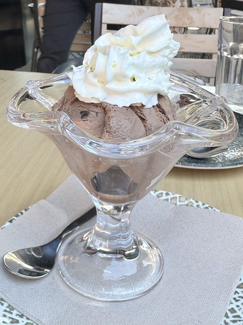 Copa de helado de chocolate con nata montada.